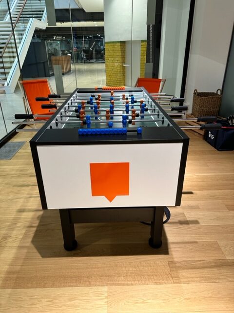 tischkicker knalldenball mit blauen und orangen figuren